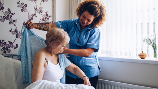 home caregiver dressing senior